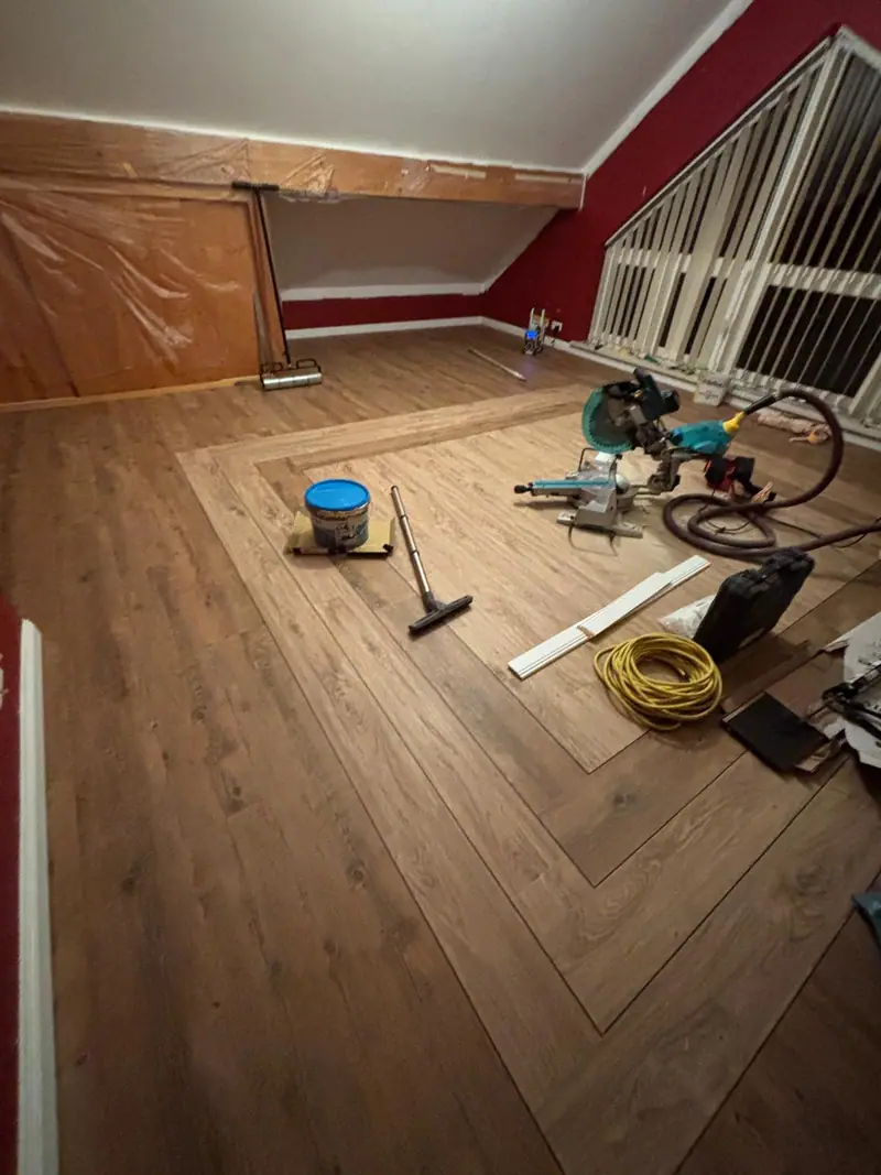 Bodenverlegung in einem Dachgeschossraum mit roter Wand