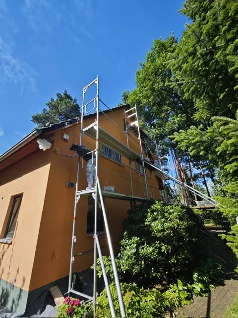 Seitliche Hausfassade mit Gerüst und frischem Fassadenanstrich