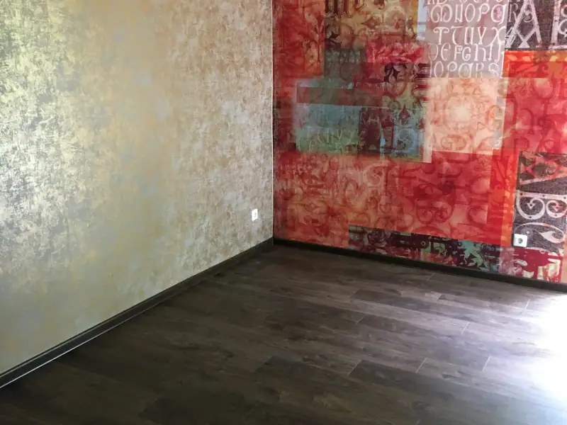 Wohnraum mit roter Akzentwand und dunklem Boden